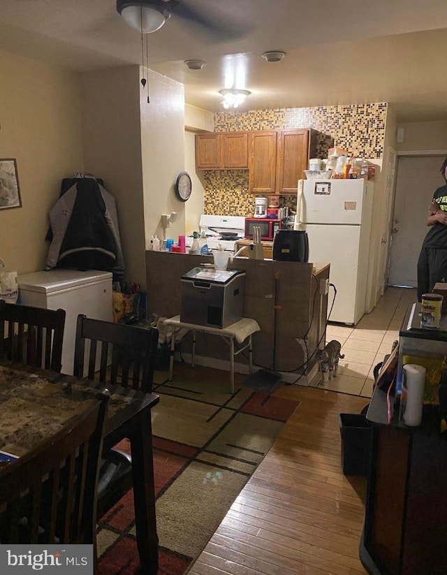 kitchen featuring tasteful backsplash, white appliances, and light hardwood / wood-style floors