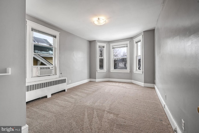 spare room featuring cooling unit, radiator, and carpet floors