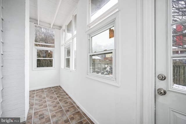 unfurnished sunroom featuring wood ceiling and beam ceiling