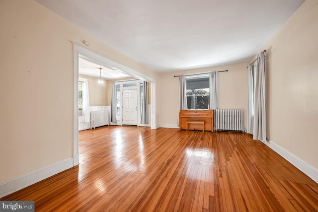 unfurnished living room with radiator and light hardwood / wood-style flooring