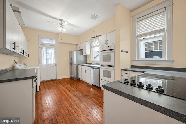 kitchen with white cabinetry, stainless steel appliances, a healthy amount of sunlight, and light wood-type flooring