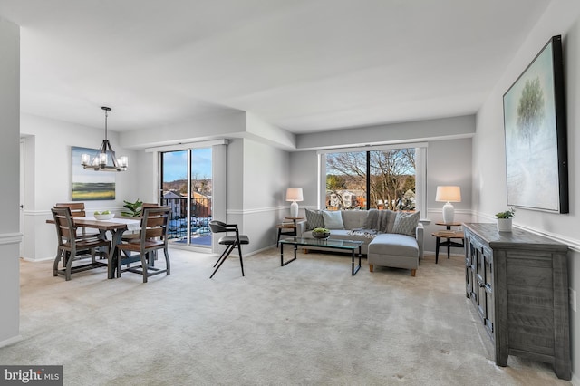 carpeted living room with an inviting chandelier