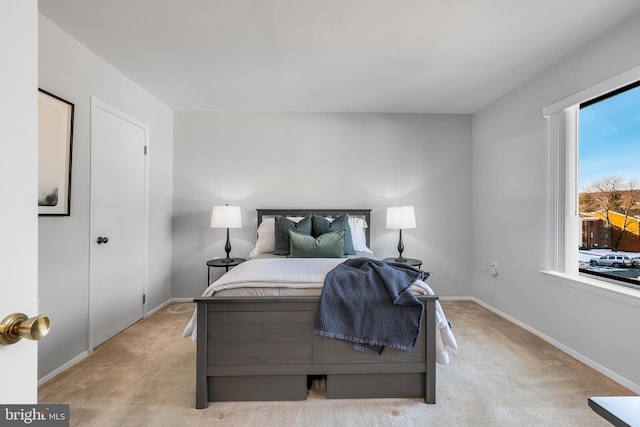 bedroom with multiple windows and light colored carpet