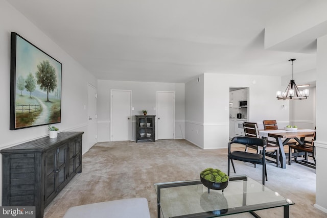 carpeted living room with a chandelier