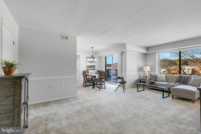 living room with light carpet and a chandelier