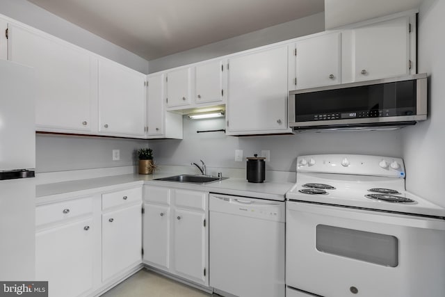 kitchen featuring white appliances, white cabinetry, and sink