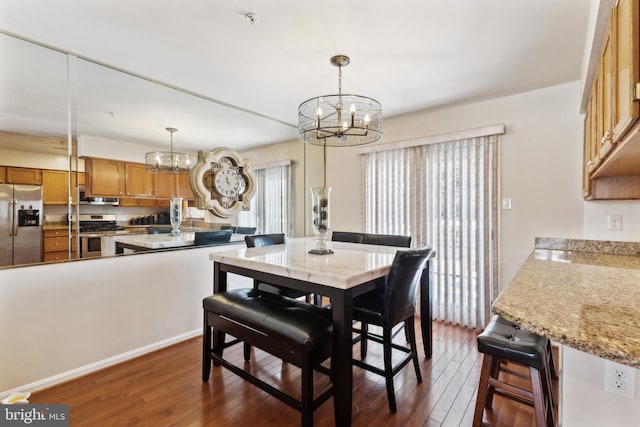 dining room featuring dark hardwood / wood-style flooring, a wealth of natural light, and a chandelier