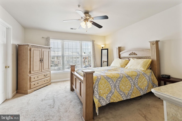 bedroom with ceiling fan and light carpet