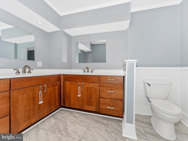 bathroom with toilet, vanity, and ornamental molding