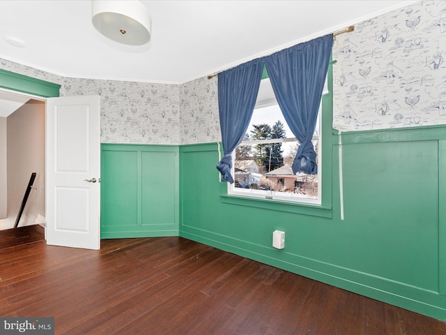 spare room with dark wood-type flooring and crown molding