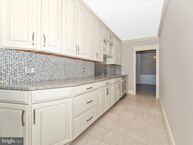 kitchen featuring decorative backsplash, sink, crown molding, light tile patterned flooring, and light stone counters