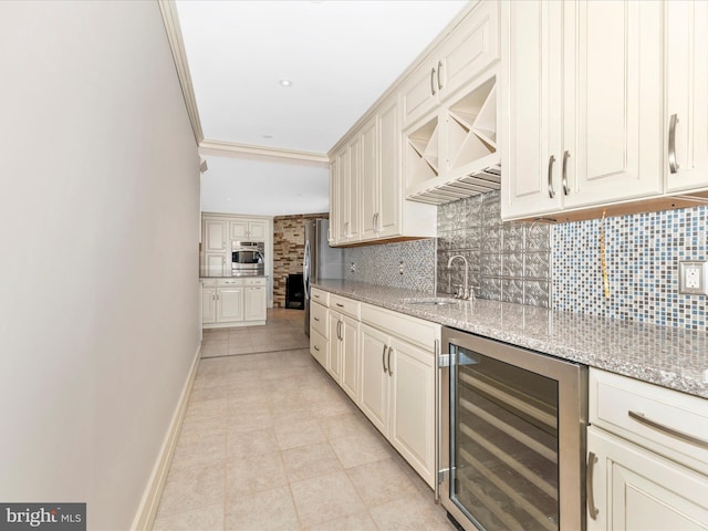 kitchen featuring sink, decorative backsplash, beverage cooler, and light stone counters