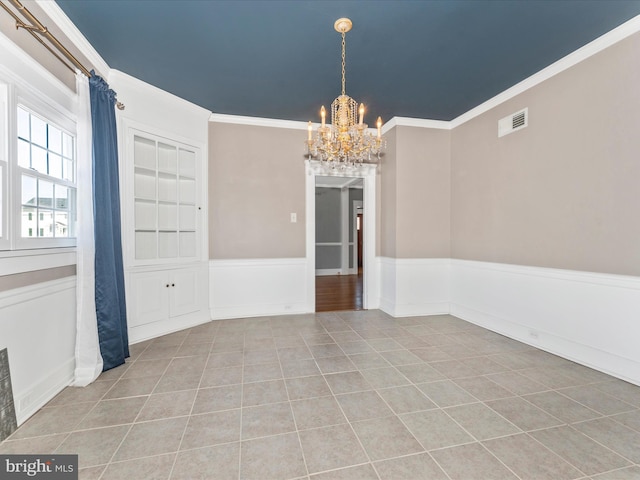 tiled empty room featuring crown molding and an inviting chandelier