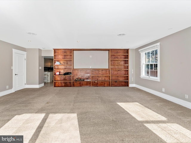 unfurnished living room with carpet floors and built in shelves