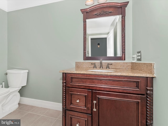 bathroom with toilet, vanity, and tile patterned flooring