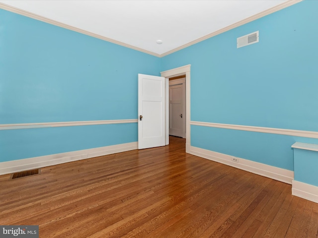 empty room featuring dark hardwood / wood-style floors and ornamental molding