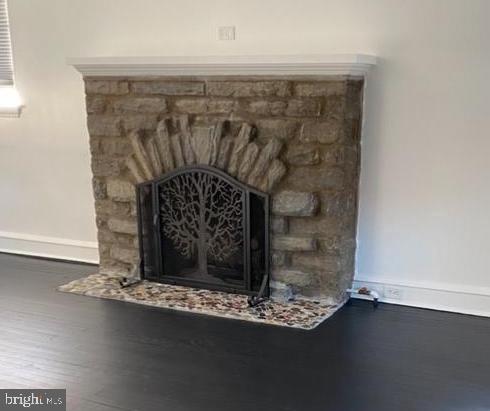 room details with hardwood / wood-style flooring and a stone fireplace