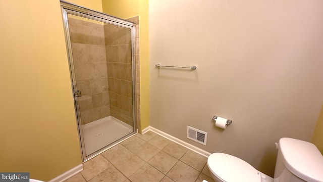 bathroom with tile patterned floors, a shower with shower door, and toilet