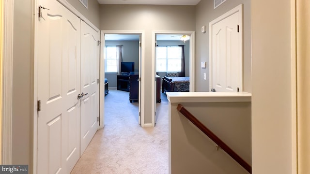 hall featuring light colored carpet