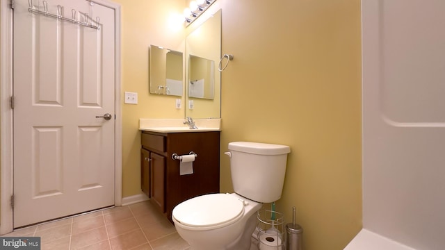 bathroom featuring vanity, tile patterned floors, and toilet