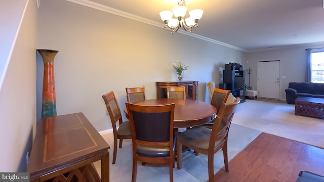 dining space with hardwood / wood-style flooring, a notable chandelier, and crown molding