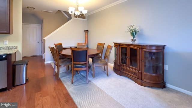 dining room featuring wood-type flooring, an inviting chandelier, and crown molding