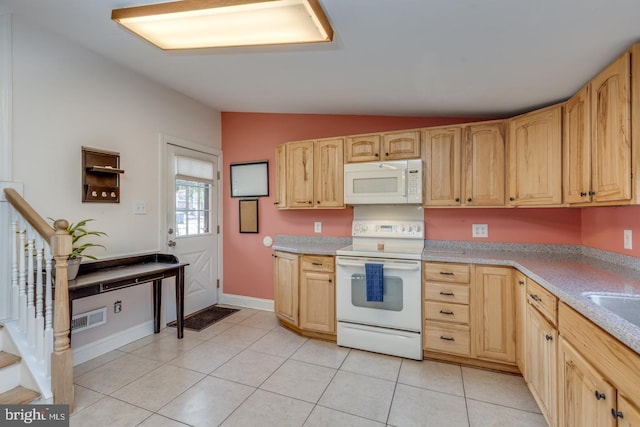 kitchen with lofted ceiling, light tile patterned floors, white appliances, and light brown cabinetry