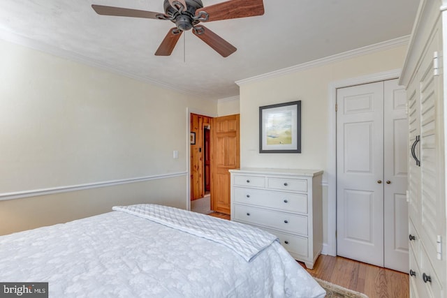 bedroom with light wood-type flooring, a closet, ceiling fan, and crown molding