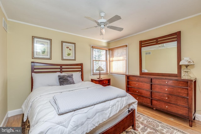 bedroom featuring light hardwood / wood-style floors, ceiling fan, and crown molding