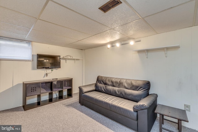 carpeted living room featuring a paneled ceiling