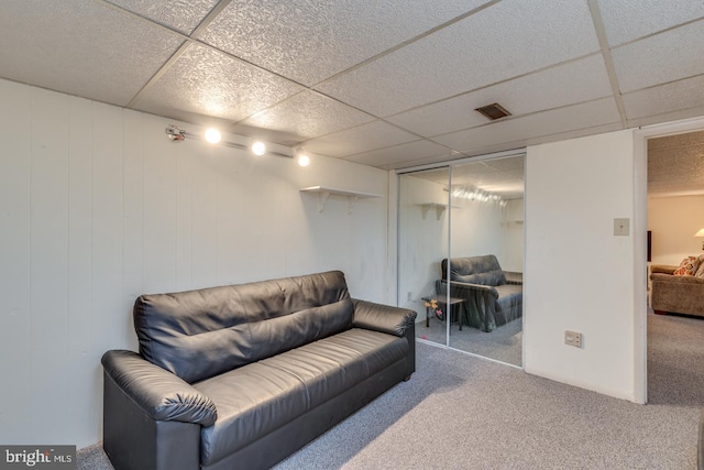 living area with carpet and a drop ceiling