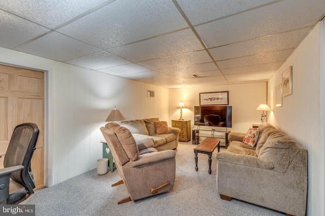 living room featuring a paneled ceiling and carpet flooring