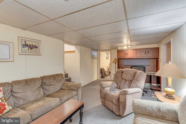 living room with a paneled ceiling and light colored carpet