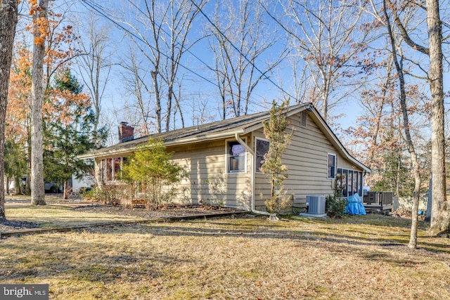 view of home's exterior featuring central air condition unit and a yard