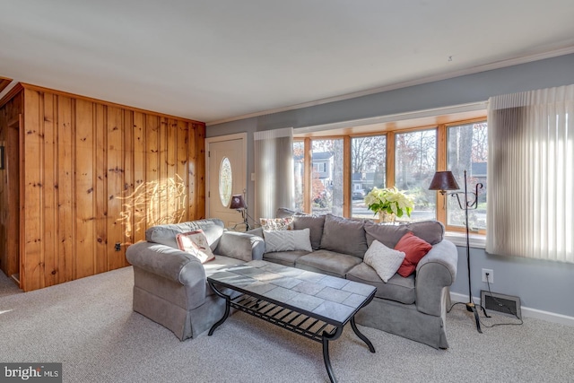 carpeted living room featuring crown molding and wood walls