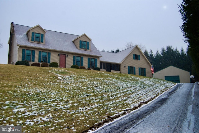 new england style home with a garage and an outdoor structure