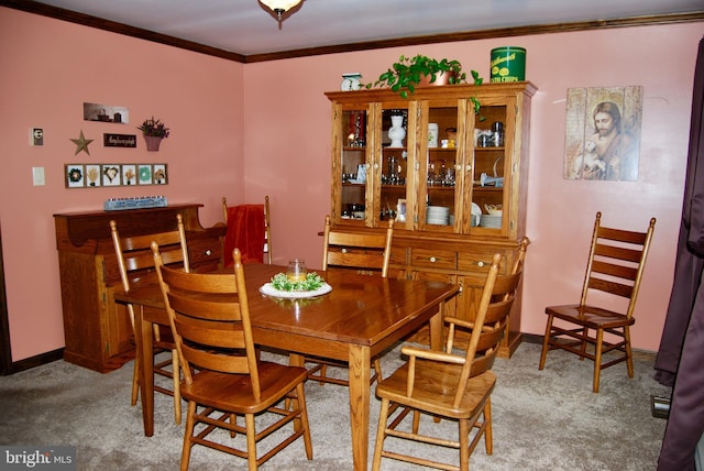 dining area with crown molding and carpet flooring