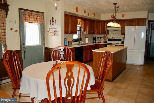 kitchen featuring sink, decorative light fixtures, range with electric stovetop, white refrigerator, and a kitchen island