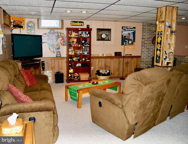 carpeted living room with wood walls