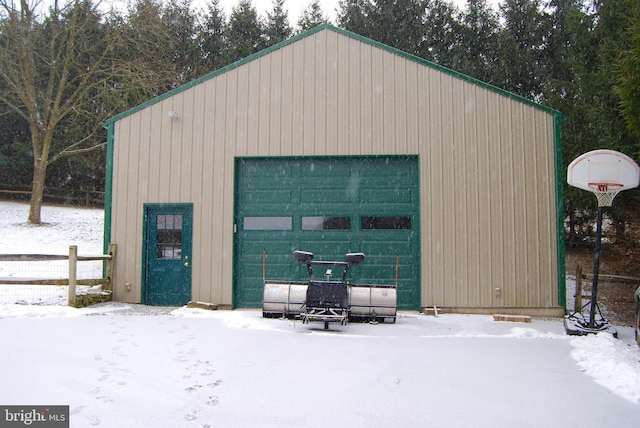 snow covered structure with a garage