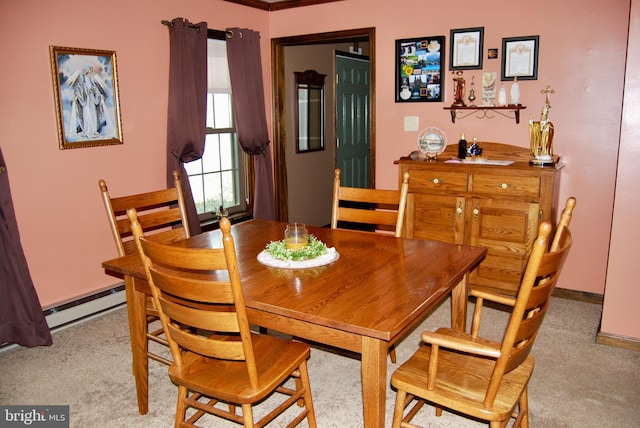 dining area featuring light colored carpet and baseboard heating