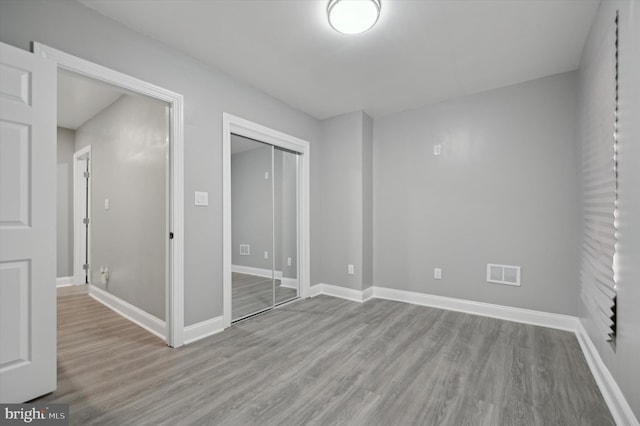 unfurnished bedroom with light hardwood / wood-style flooring and a closet