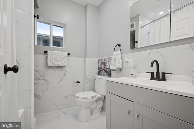 bathroom featuring vanity, toilet, tile walls, and walk in shower