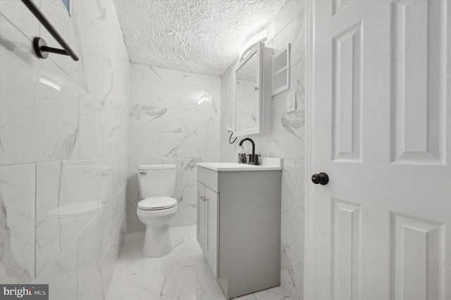 bathroom with vanity, toilet, and a textured ceiling