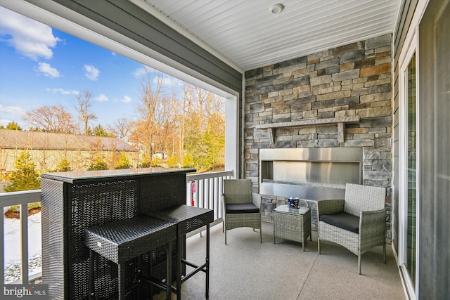 balcony featuring an outdoor stone fireplace