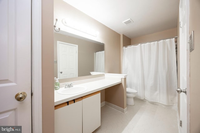 bathroom with tile patterned flooring, vanity, and toilet