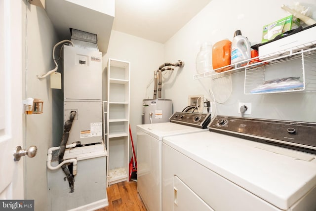 laundry room with washing machine and dryer, water heater, and light wood-type flooring