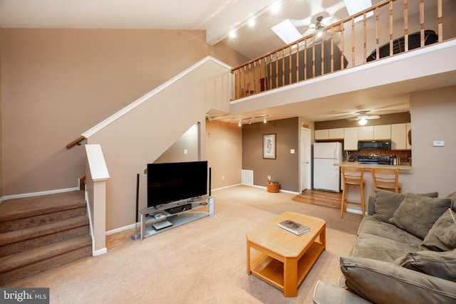 carpeted living room featuring beam ceiling, ceiling fan, high vaulted ceiling, and track lighting