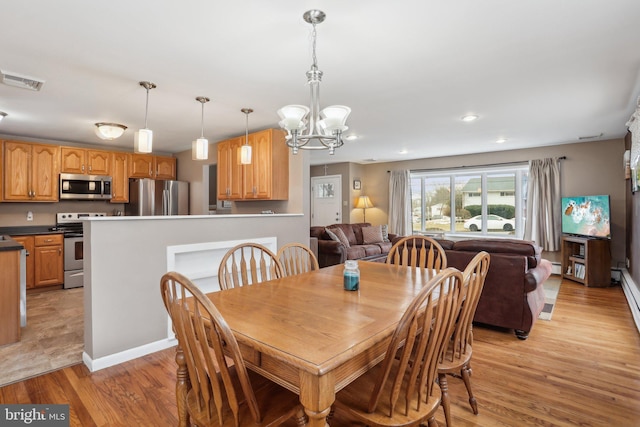 dining space featuring light wood-type flooring, baseboard heating, and an inviting chandelier