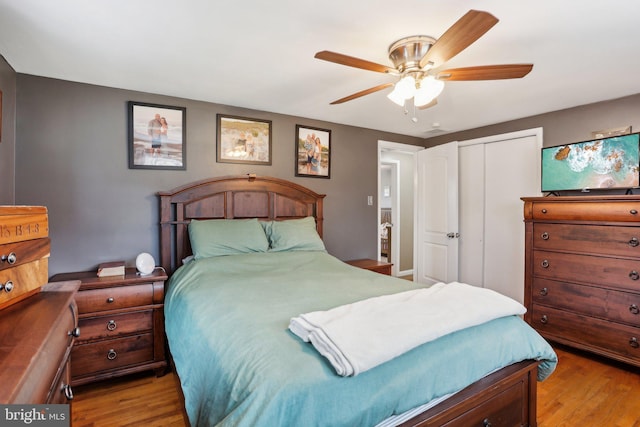 bedroom with ceiling fan, light wood-type flooring, and a closet